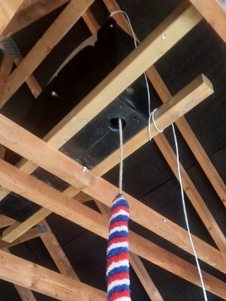 View of customised Home Dumbbell installed in the open loft rafters of a large garage, showing rope and sally, ready to ring. 3 of 3